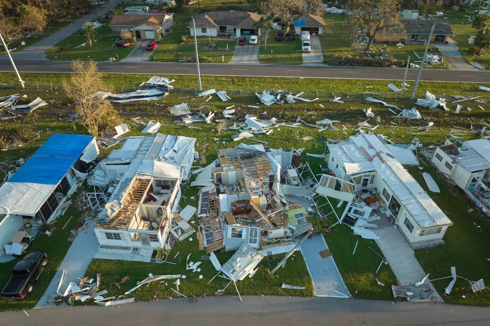 Aerial view of heavily damaged mobile homes after a hurricane in Florida.